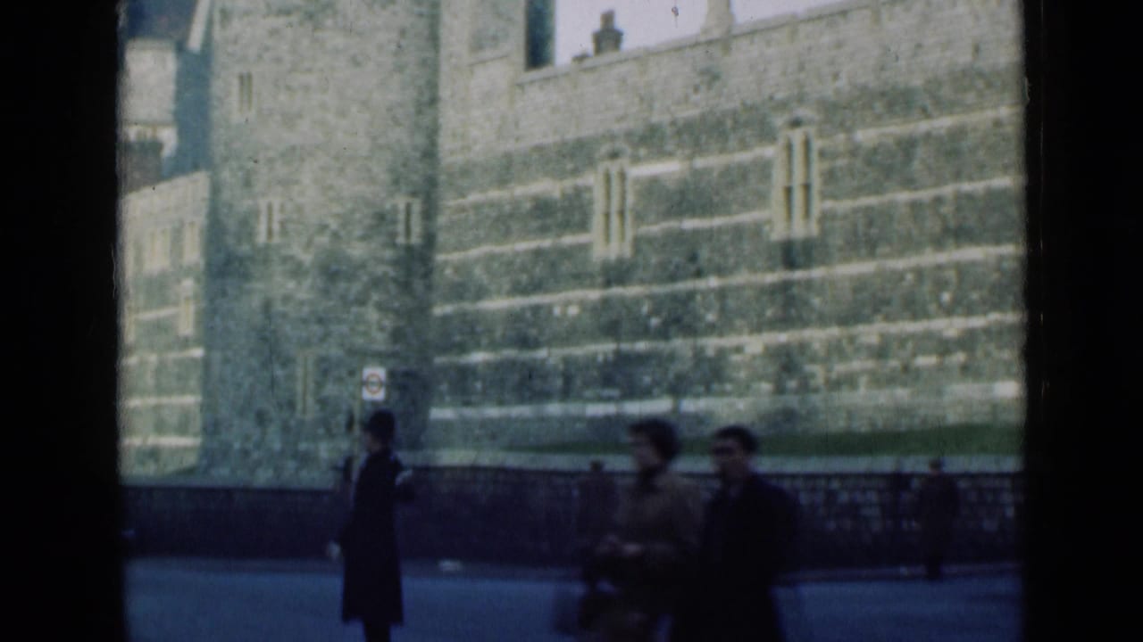 1946 London street view with pedestrians, a uniformed policeman, railings, and massive stone landmark walls in the background.