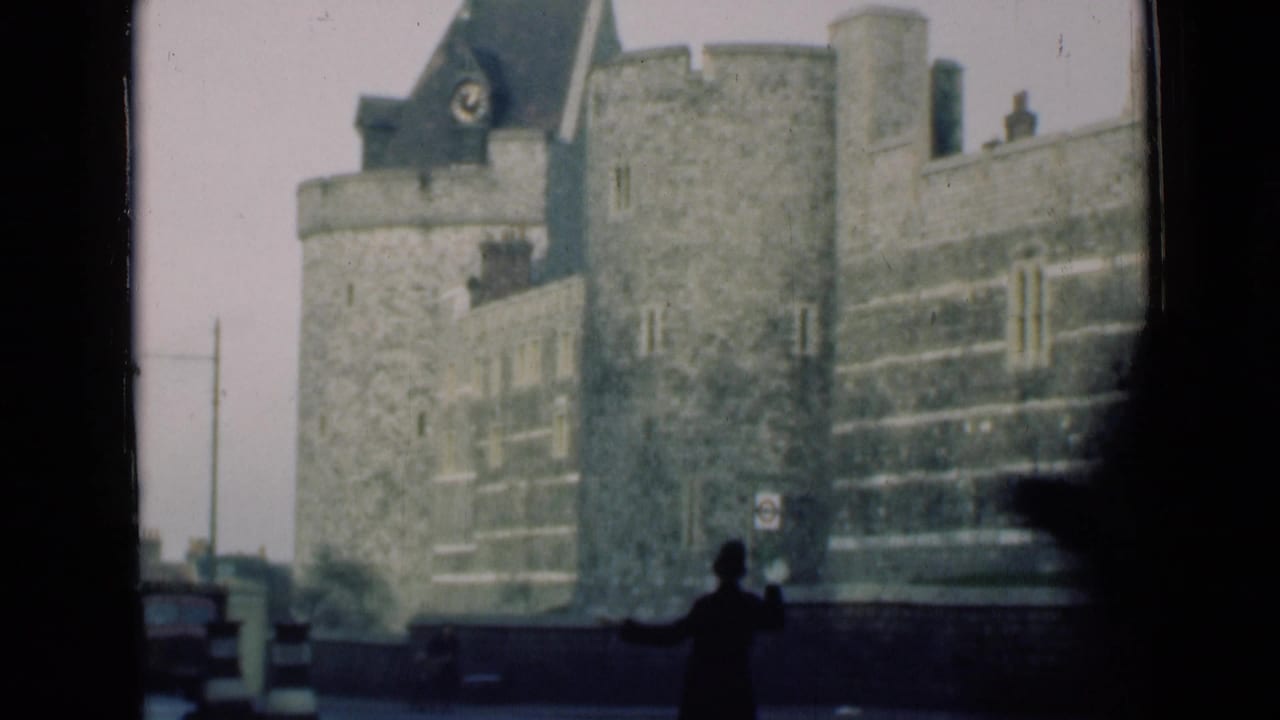 Pedestrian silhouette near a large turreted stone building along the street.