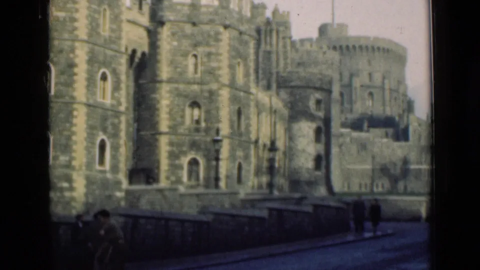 1946 home-movie view of Windsor Castle from across a street, with pedestrians near the stone wall and soft 8mm color.