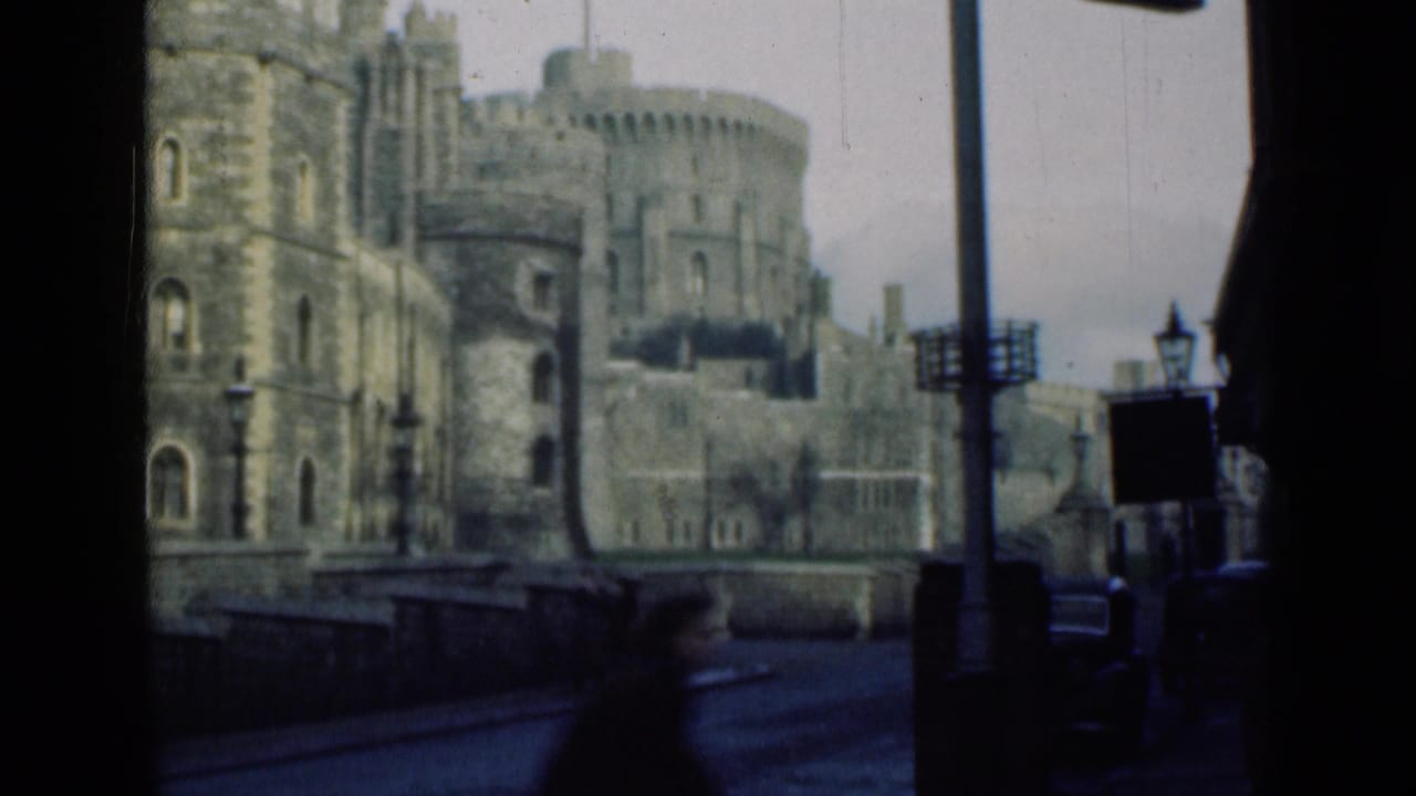 1946 8mm view of Windsor Castle stone towers and battlements from a street-level position under an overcast sky.