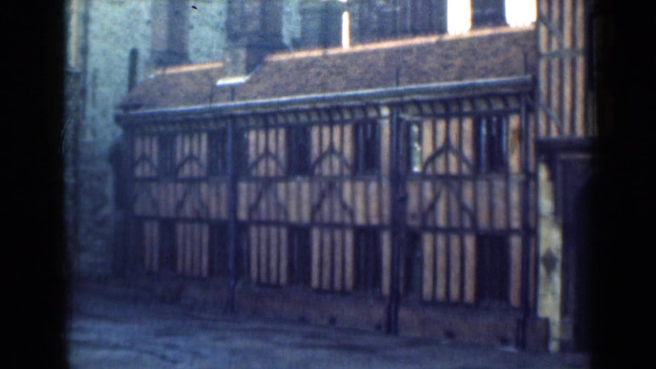 Half-timbered wall panels and arched window patterns beside a dark doorway.