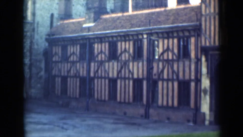 1946 London home-movie frame showing the timber-framed building facade from a slightly lower street-level angle.