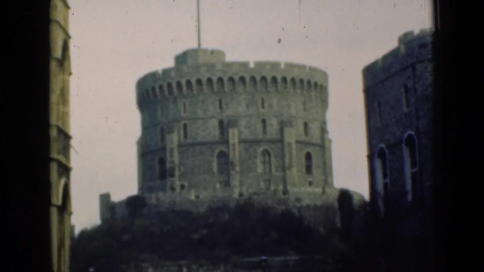 1946 8mm view of Windsor Castle's Round Tower, seen through a dark-edged opening with a flag flying above the stone structure.