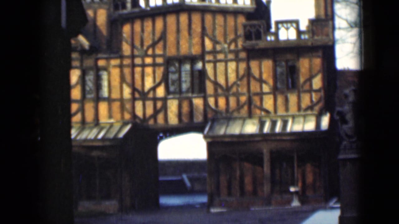 Close view of orange timber-framed facade with dark beams and small windows.