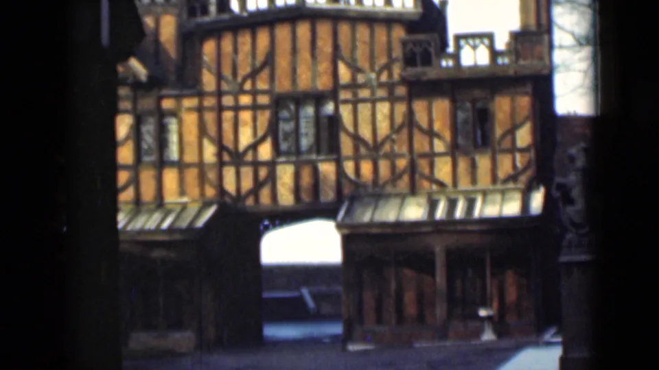 1946 London frame of a timber-framed building facade, with the arched passage and shadowed foreground still visible.