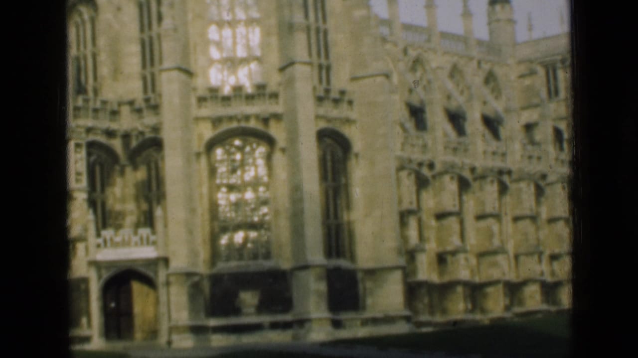 1946 London home-movie frame showing a Gothic-style stone exterior with arched windows and decorative masonry.