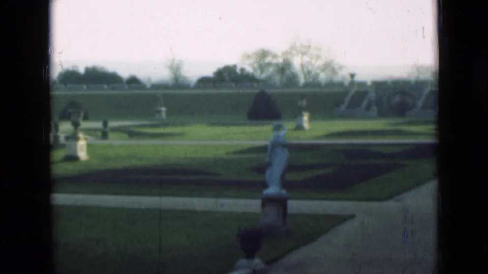 1946 London frame showing a formal garden layout with a statue, clipped lawns, paths and low hedges.