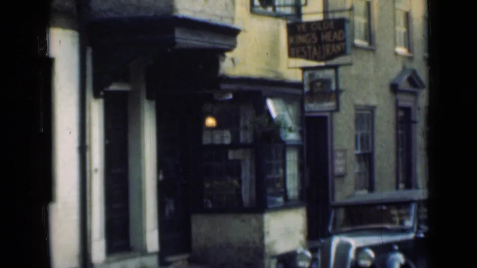 1946 London street view showing the Ye Olde King's Head Restaurant sign, building frontage, windows, sidewalk, and a parked car.