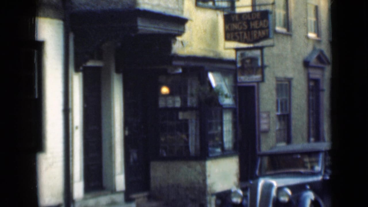 1946 London street view of Ye Olde King's Head Restaurant frontage with a hanging sign, lit window, and vintage car edge.