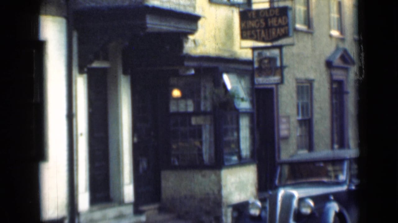Static 1946 London home-movie frame showing the pub sign, recessed entrance, shopfront window, and parked vintage car.