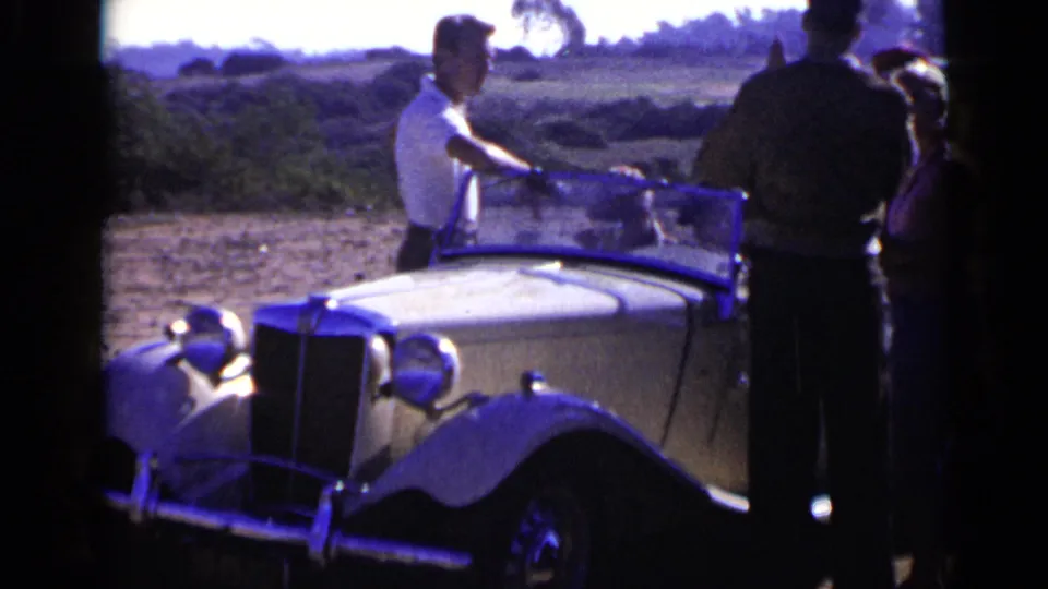 1949 San Diego home-movie frame showing the roadster from the front quarter with adults gathered near the windshield.