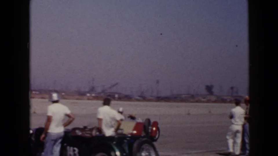 The final frame shows men beside a vintage car on a broad paved San Diego airfield area, with the background falling into haze.