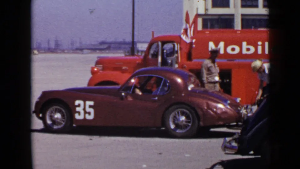 San Diego 1949 home-movie view of a number 35 maroon race car, a red Mobil oil truck, and crew activity at a race setting.