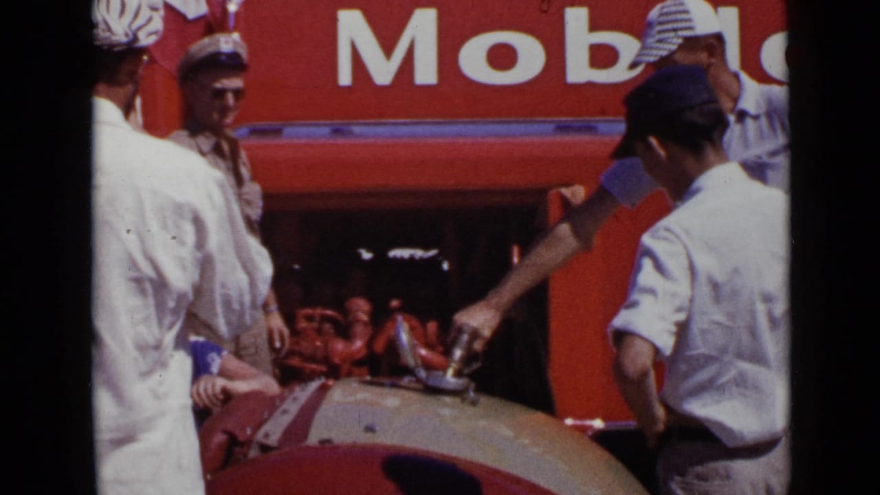 Men stand around a rounded vehicle tank near large Mobil lettering while fuel is handled.