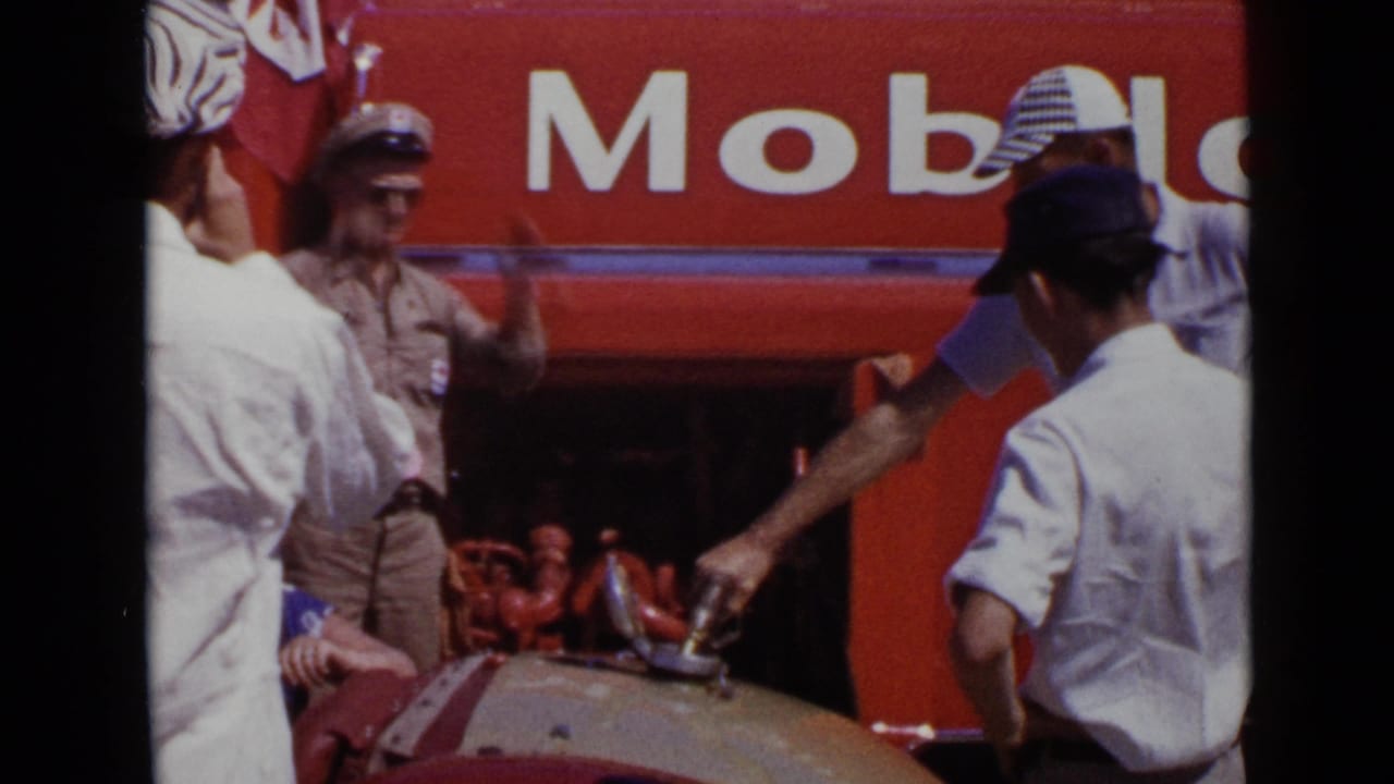 1949 San Diego frame with a man handling fuel near a rounded tank while others stand beside prominent Mobil signage.