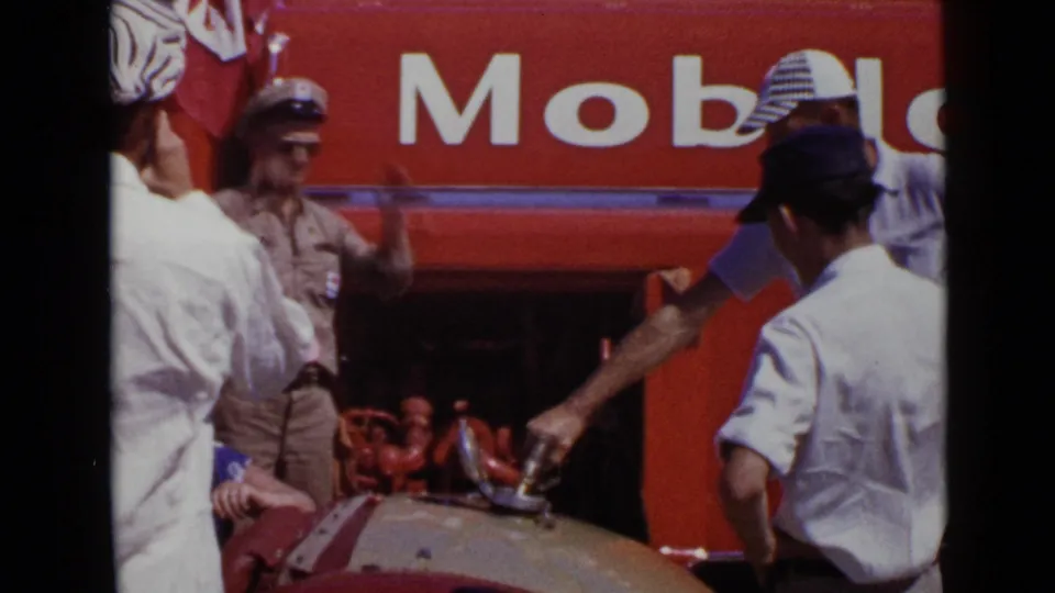 1949 San Diego frame with a man handling fuel near a rounded tank while others stand beside prominent Mobil signage.