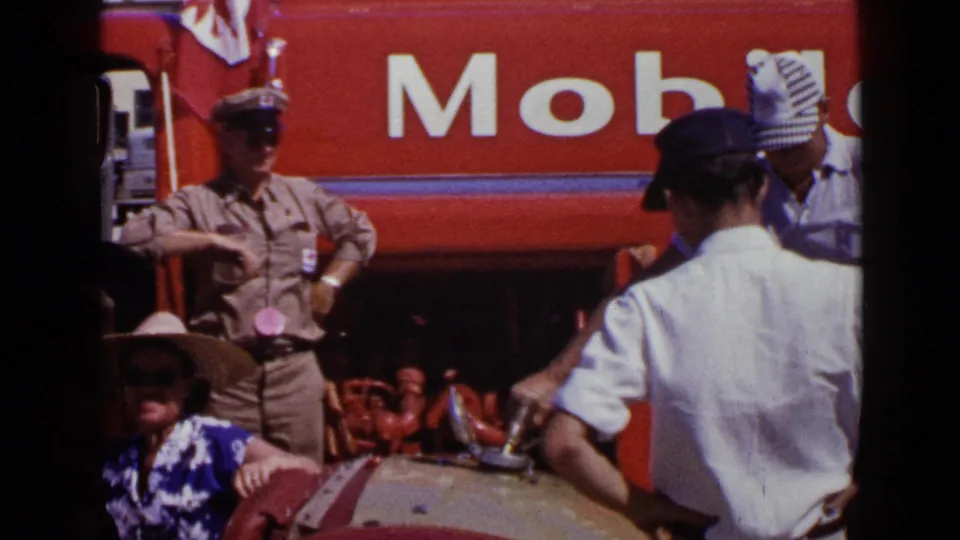 1949 San Diego frame showing a uniformed attendant and several men by a red Mobil refueling scene and rounded tank.