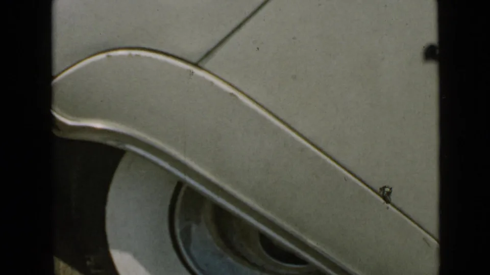 A close-up of a mid-century car detail shows curved chrome trim and bodywork, continuing the home-movie transition from the pier scene.