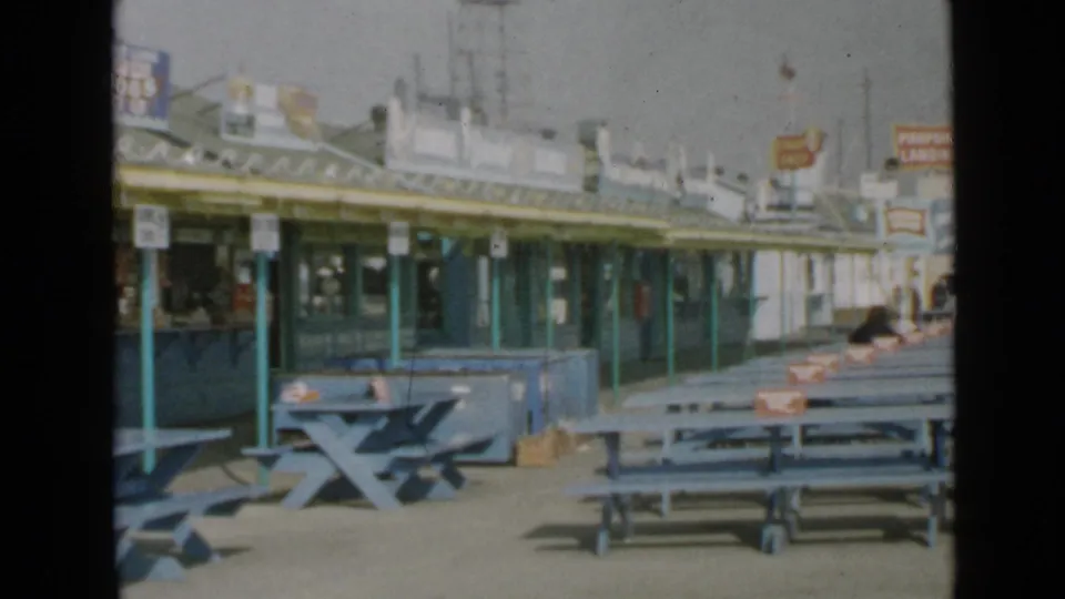 The 1949 San Diego pier view shows repeated blue seating, green posts, and concession fronts in a visitor-shot composition.