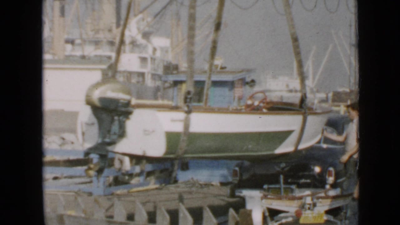Small motorboat hangs or rests near the dock with an outboard motor visible at the stern.