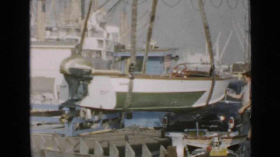 Small motorboat at a San Diego dock in 1949, with its outboard motor visible and another person partly seen at the right edge.