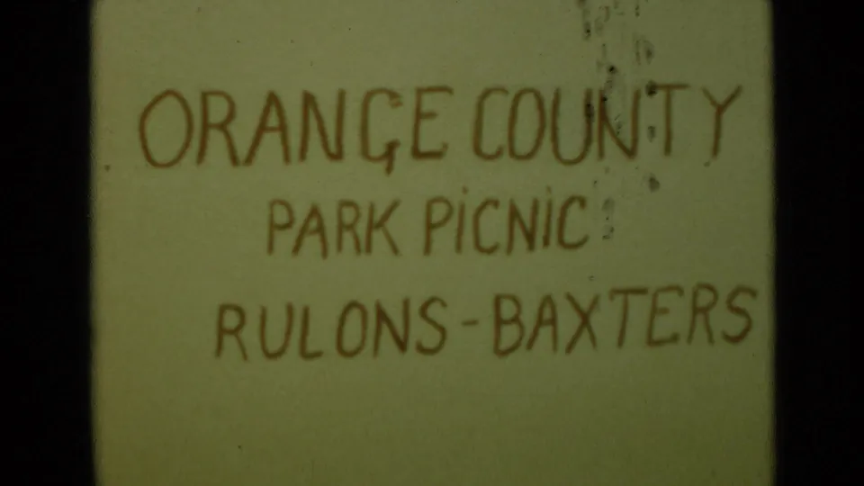1949 8mm home-movie title card for an Orange County Park picnic, with handwritten Rulons-Baxters text on a pale background.