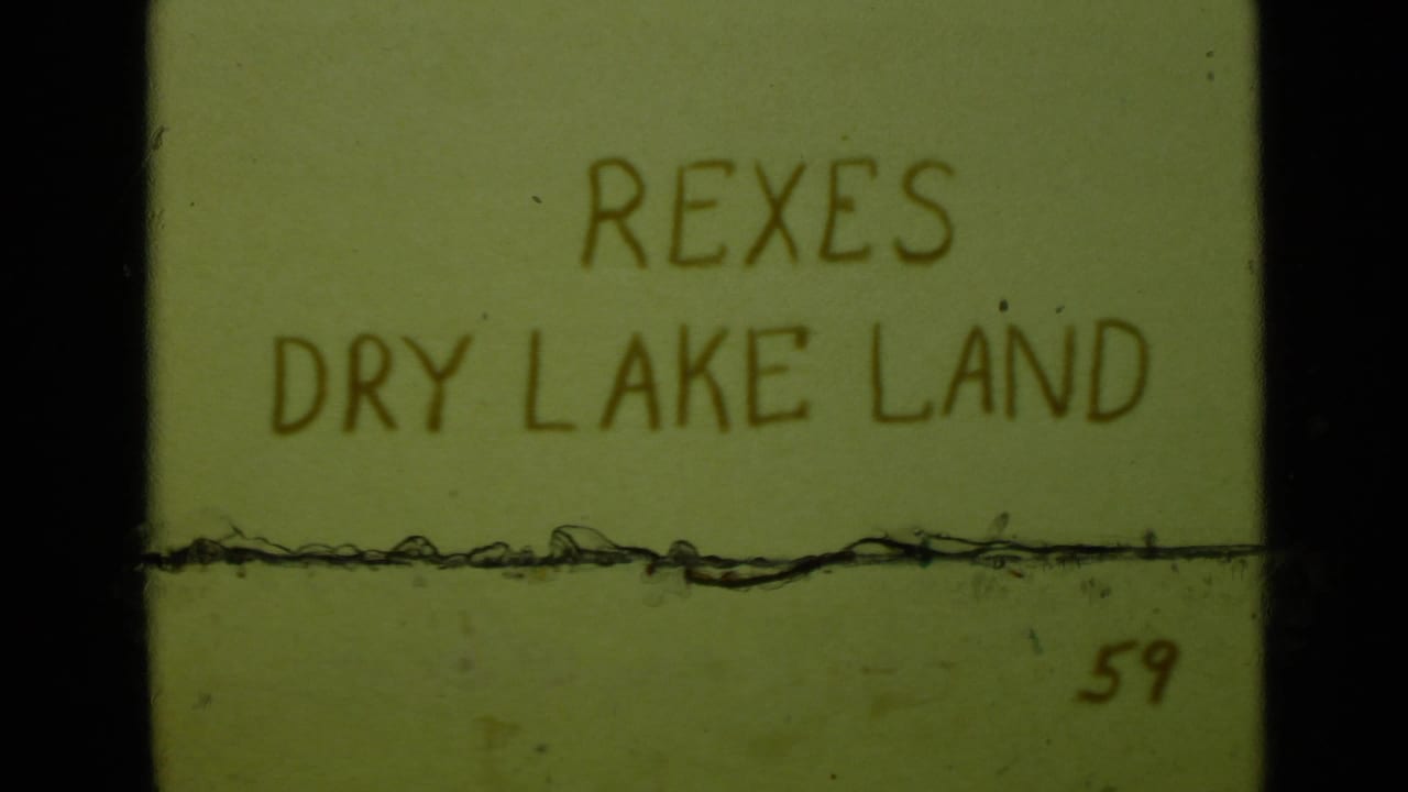 Second title-card frame reading REXES DRY LAKE LAND with a visible film scratch line.