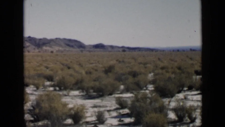 1949 home-movie view of arid San Diego-area scrubland, sandy ground, low hills, and soft 8mm frame borders.