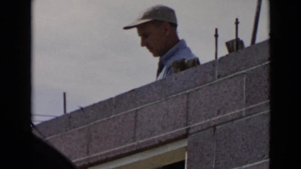 1949 San Diego frame showing the capped construction worker behind courses of concrete block.