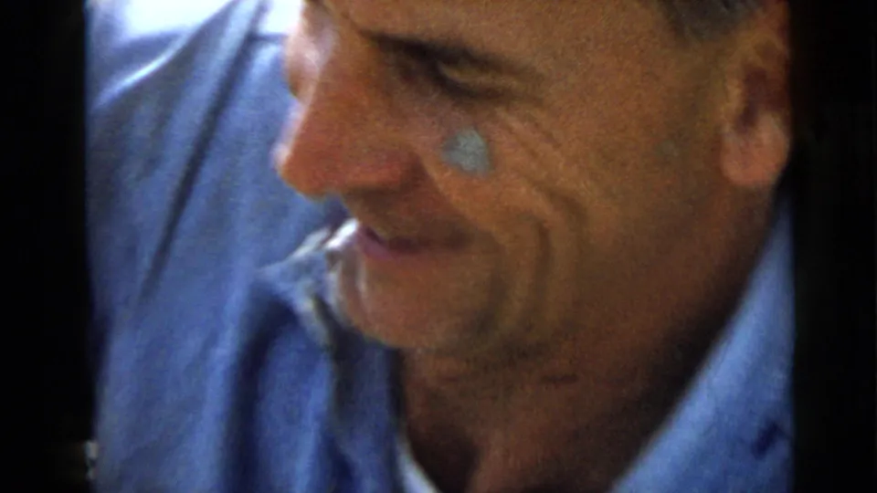 Close 1949 San Diego frame of a smiling adult man in a blue shirt, with faded color and dark 8mm frame borders.