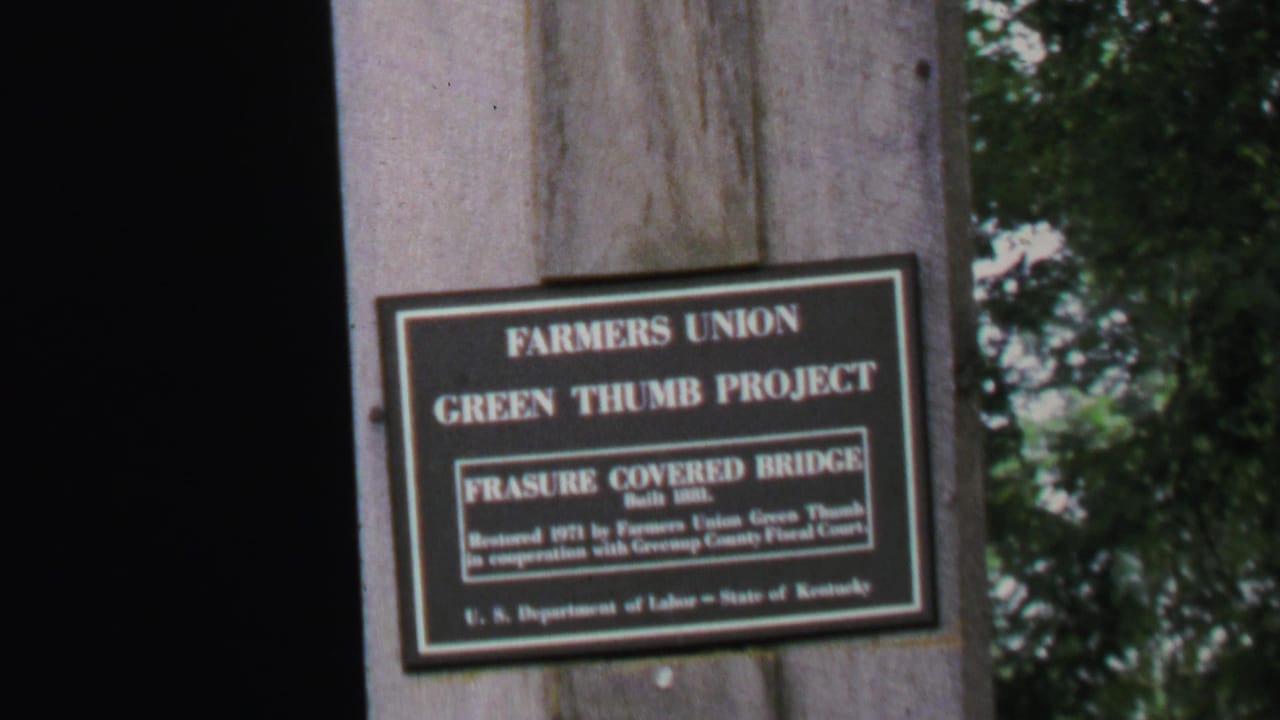 Close-up sign on a timber support with trees visible in the background.