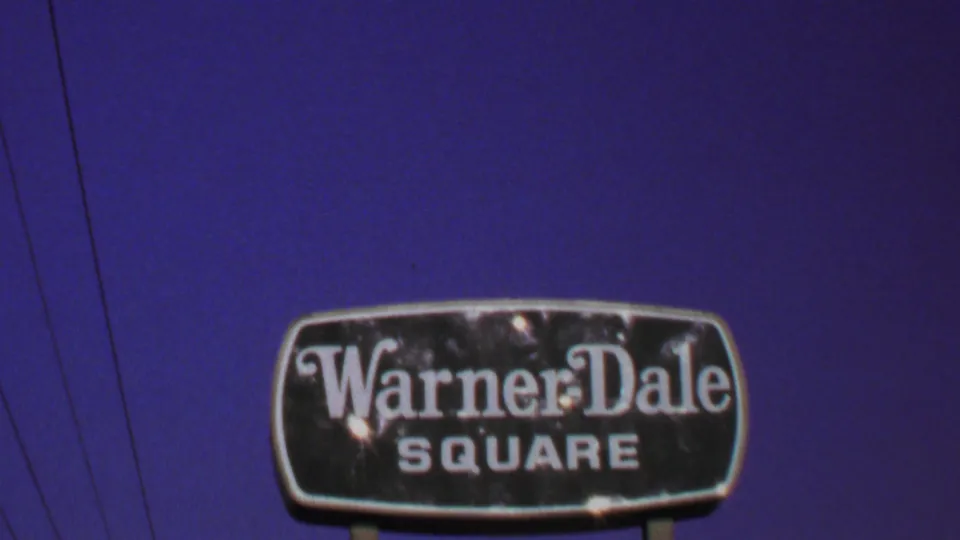 Centered 1969 Washington, DC-area view of the Warner-Dale Square sign on two posts, with blue sky and faint utility wires in the background.