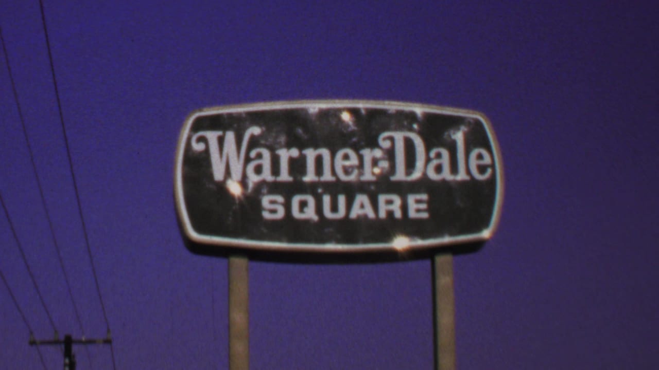 Warner Dale Square sign near the top of frame with utility pole and wires behind it.