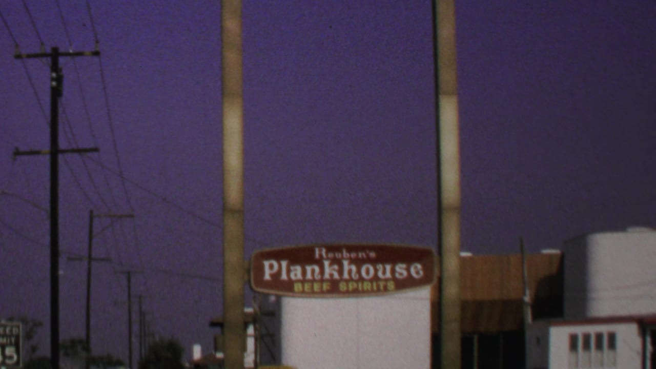 1969 Washington, DC frame with the Reuben's Plankhouse sign partly framed by utility poles, wires, and the restaurant exterior.
