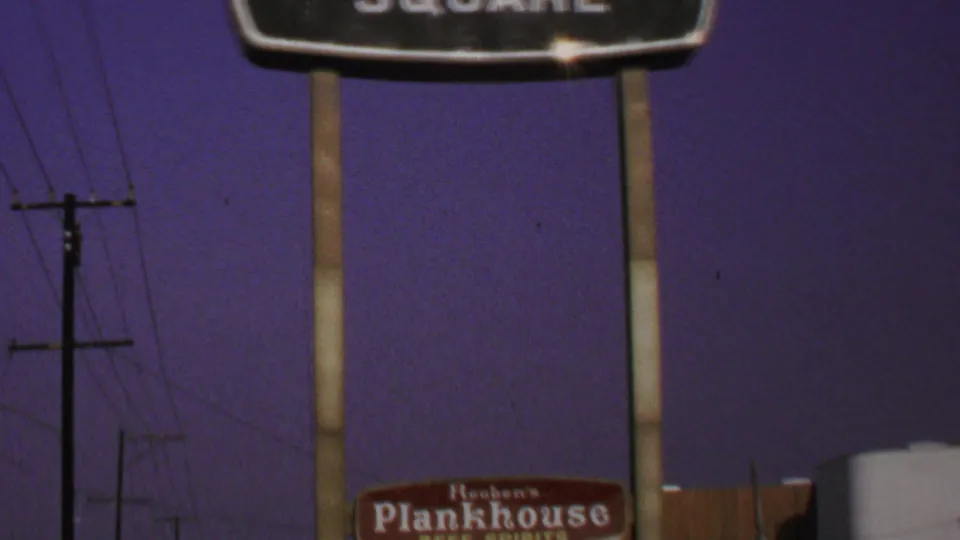 1969 Washington-area frame showing the Warner-Dale Square sign above Reuben's Plankhouse signage and roadside utility lines.
