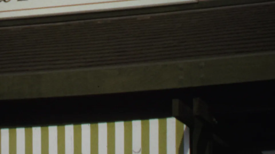 Close storefront detail with striped awning, building trim, and shaded window area in the 1969 Washington, DC clip.
