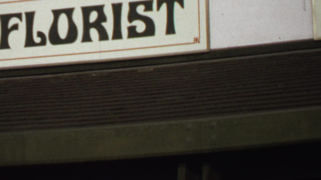 Partial storefront sign with large black FLORIST lettering on a cream panel.