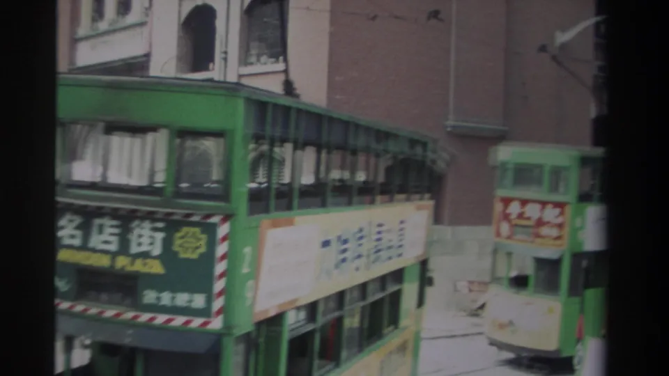 1982 Hong Kong frame showing a green double-decker transit vehicle with Minden Plaza signage and another green vehicle nearby.