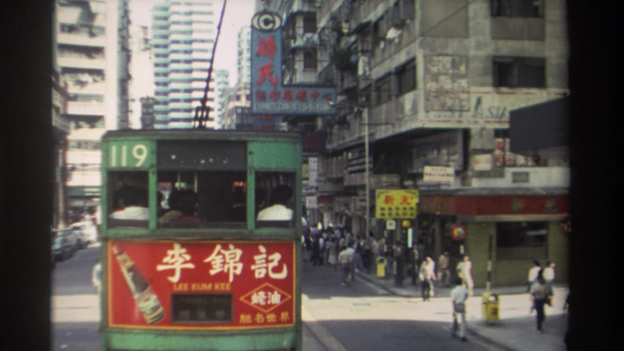 1982 Hong Kong street view with green tram 119, red Lee Kum Kee advertising, pedestrians, Chinese signage, and high-rise buildings.