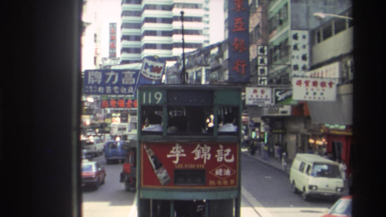 1982 Hong Kong street view from a moving vehicle, with a green route 119 double-decker tram and dense Chinese signage.