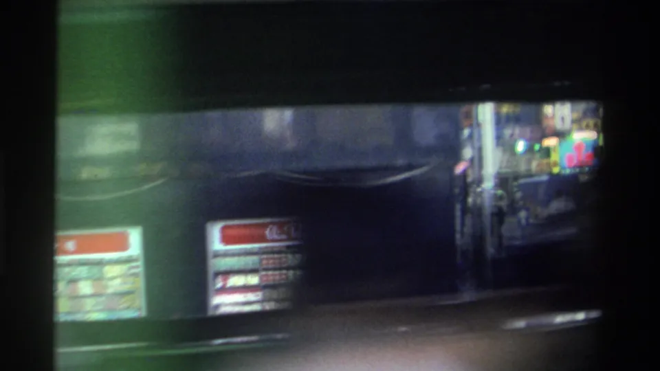 Green double-decker bus or tram alongside the camera in 1982 Hong Kong; red route board with Chinese characters and coloured neon signs visible behind.