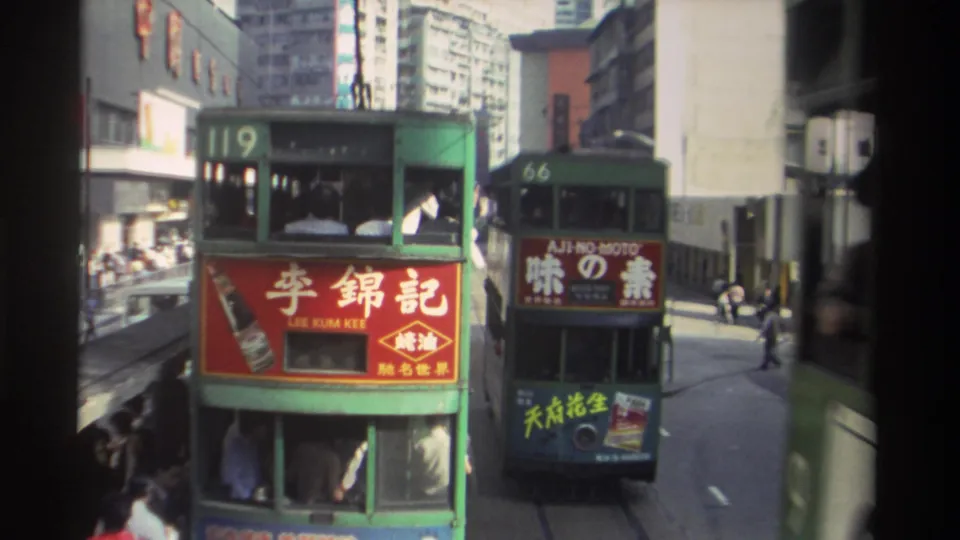 Trams 119 and 66 in close proximity on a 1982 Hong Kong tram corridor, Lee Kum Kee soy sauce, Aji-no-Moto, and additional Chinese commercial signage legible, high-rise streetscape behind.