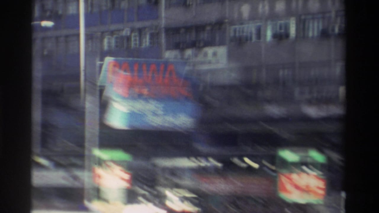 Heavily motion-blurred 8mm frame from Hong Kong, 1982, showing the PALWA billboard and layered commercial signage across multi-storey building facades.