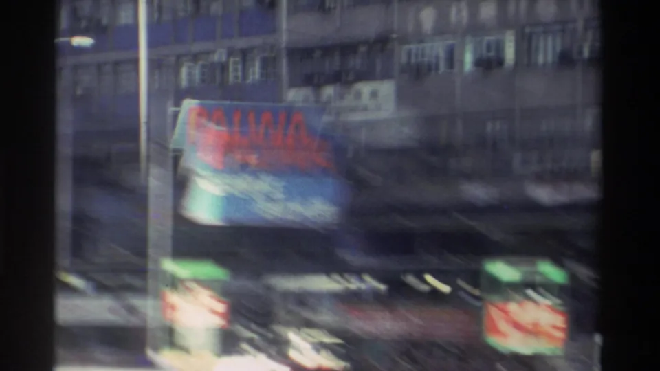 Heavily motion-blurred 8mm frame from Hong Kong, 1982, showing the PALWA billboard and layered commercial signage across multi-storey building facades.
