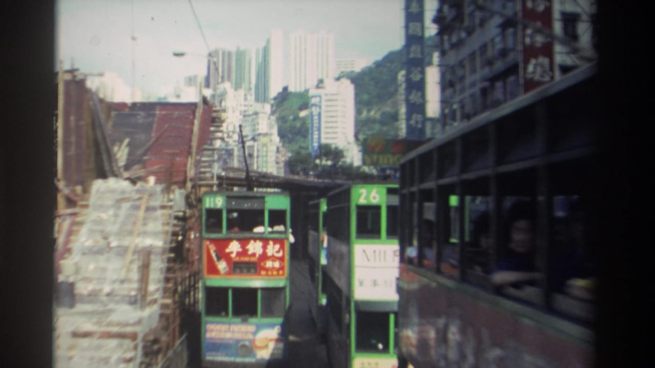 Two green trams approach as another tram passes close along the right edge.