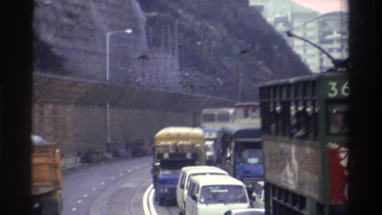 Hong Kong tram no. 36 in heavy traffic beside a rocky cliff face, filmed from inside a moving vehicle, circa 1982, 8mm film.
