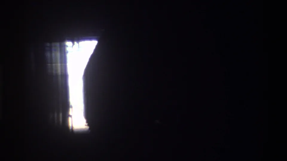 Hong Kong, 1982 — dark tunnel or station interior with residual daylight at frame edges after train passage, 8mm home movie end of clip.