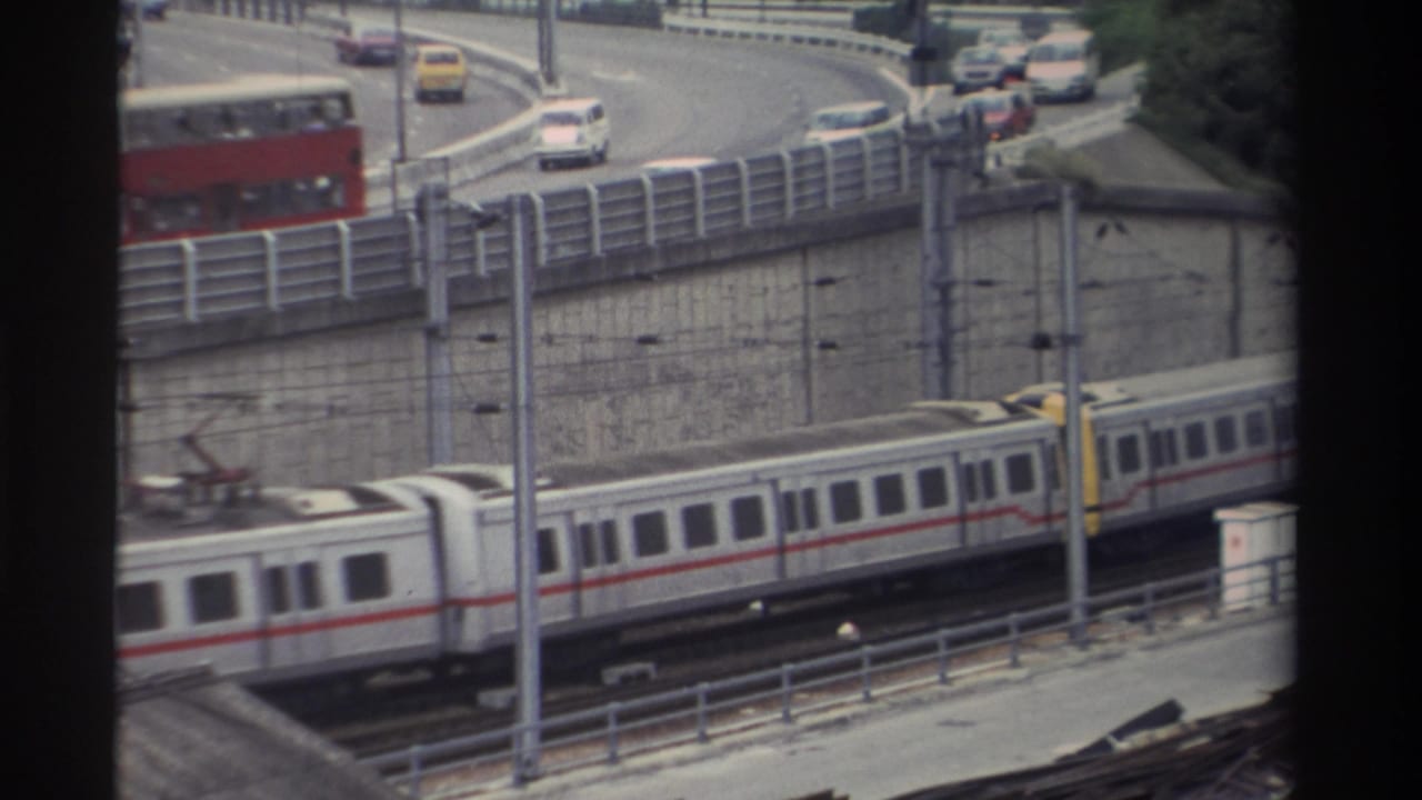 8mm frame from Taiwan, c.1982; train has moved right while the red double-decker bus occupies the centre of the curved elevated road.