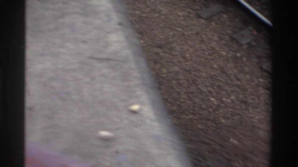 End-of-clip frame showing out-of-focus railway tracks and ballast; the worker has walked beyond frame, leaving only track infrastructure visible.