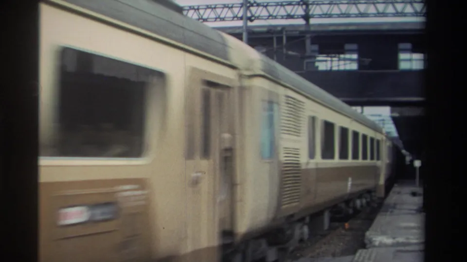Passenger train passing through a covered station with pronounced motion blur, Taiwan, 1982, 8mm home movie.